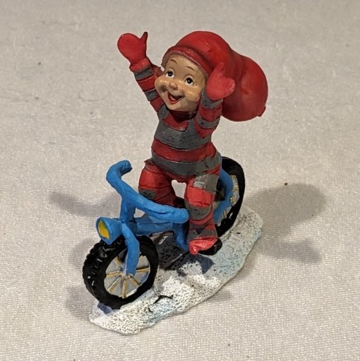 Baby-Elf-Junge, der ohne Hände auf einem blauen Fahrrad radelt